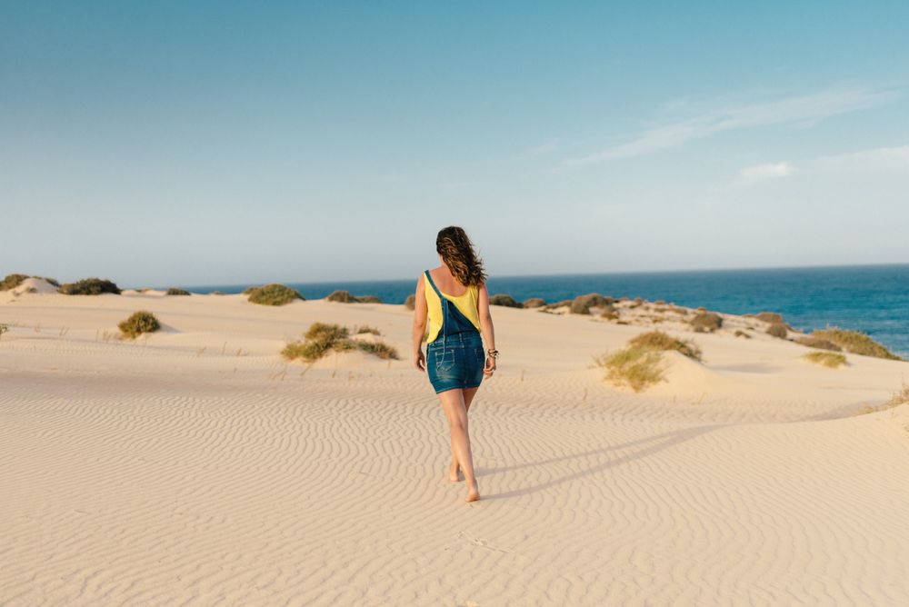 Active woman walking in dry desert barefoot