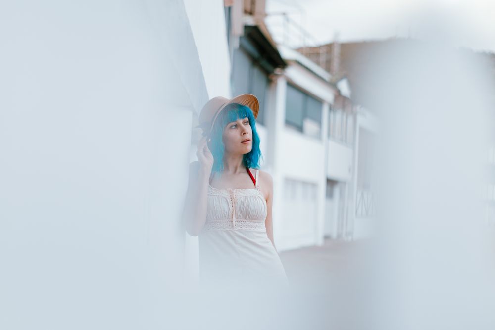 Carefree woman in sundress walking along sunny street