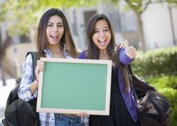 Female Students with Thumbs Up Holding Blank Chalkboard