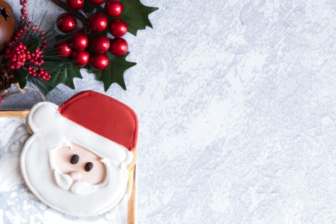 Santa Cookie in a plate on a grey backdrop with Christmas decorations. Snow theme.