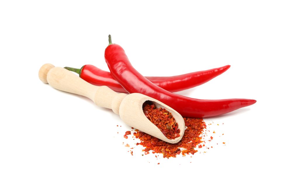 Scoop with spice and chilli peppers isolated on blank background