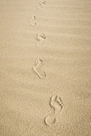 Bare feet footprints on sand