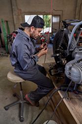 Male mechanic repairing motorbike in workshop