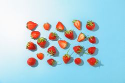 Flat lay composition with strawberries on color background, space for text. Summer sweet fruits and berries
