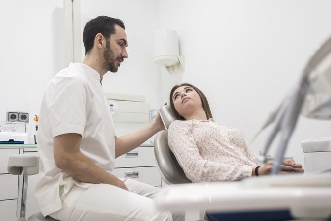 Portrait of a dentist explaining procedure to a female patient