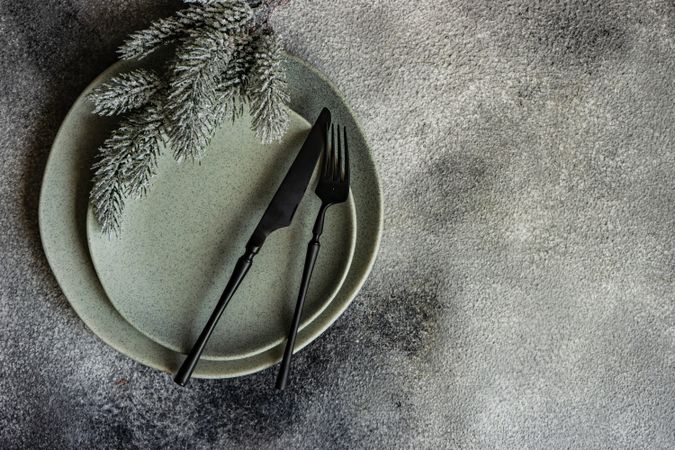 Top view of Christmas table setting with snowy pine branch