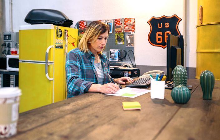 Blonde young woman checking orders received by ecommerce shop