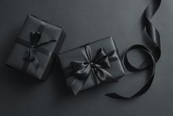 Gift boxes with dark bows on dark background