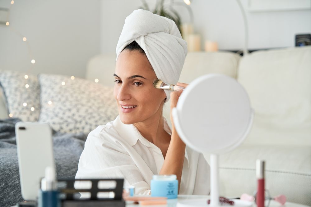 Content woman applying makeup and recording blog