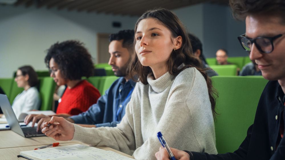 Female Student Studying in University with Diverse Multicultural Colleagues.