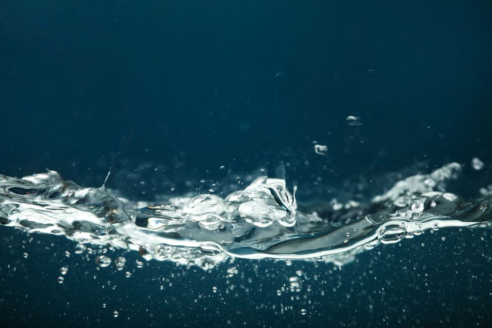 Side view of water splashing on dark background