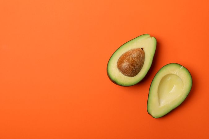 Ripe fresh avocado on orange background, top view