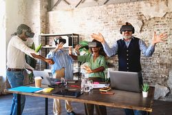 Group of co-workers testing a project using virtual reality googles in the office together
