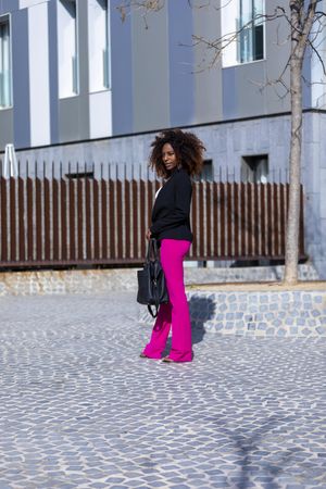 Full body shot of Black female standing outside in the sunshine