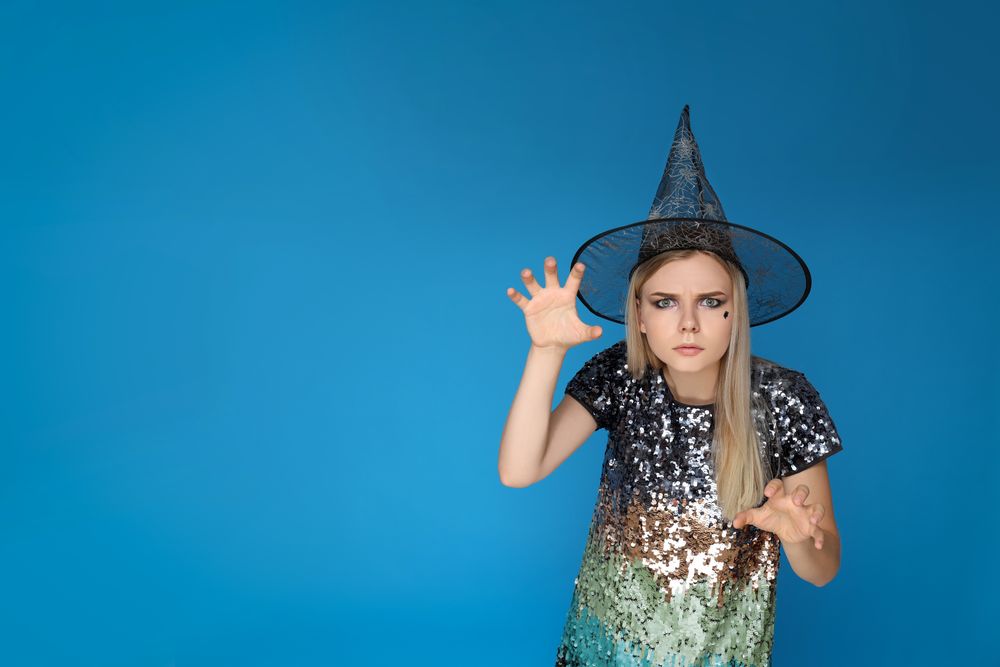 Concept of Halloween, young woman on blue background