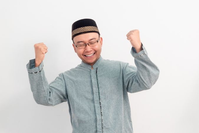 Asian Muslim man smiling doing successful gesture in Ramadan