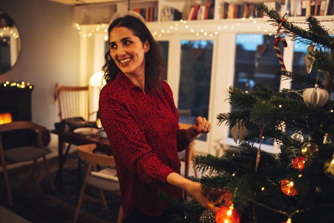 Woman looking away while decorating Christmas tree
