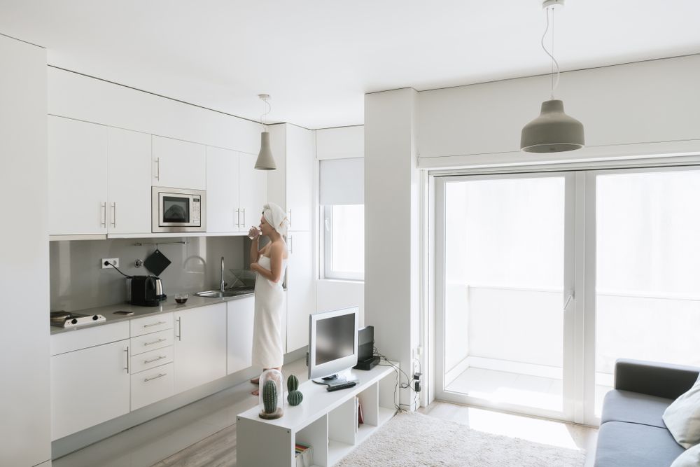 Pensive serene woman having refreshment with water in comfortable kitchen