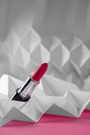 Pink lipstick on raised chevron. Product and make up contemporary concept