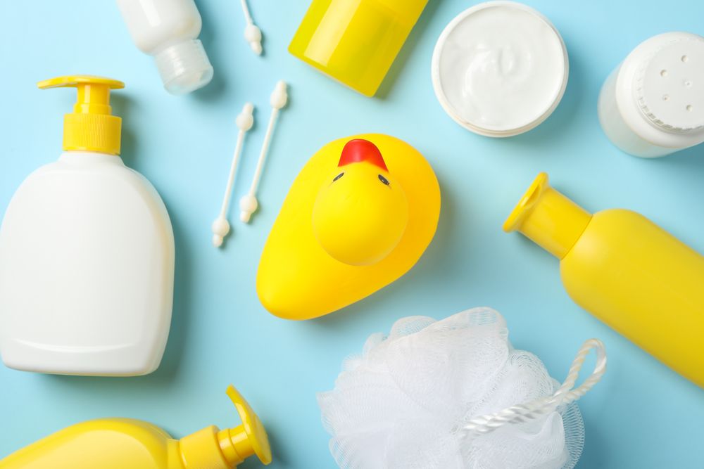Baby hygiene accessories on blue background, top view