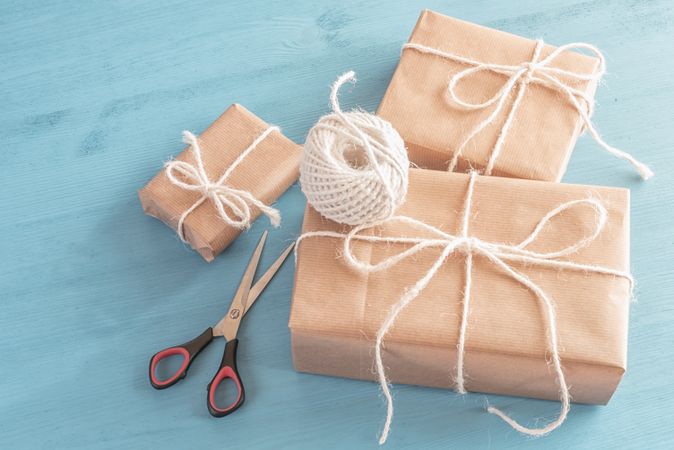 Three presents wrapped in brown paper and tied with twine