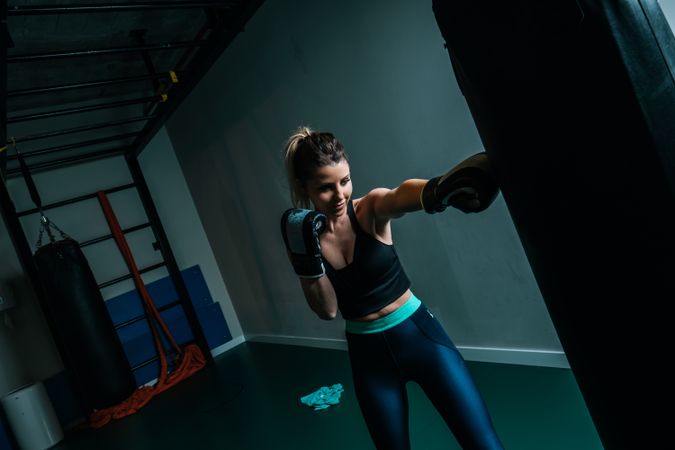 Woman training in gym with punching bag