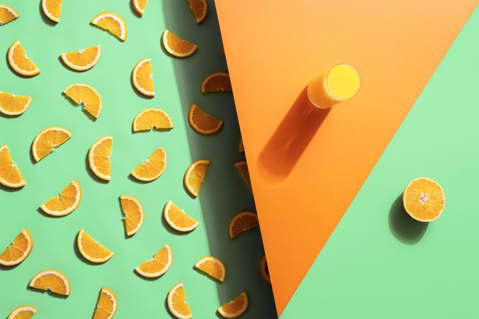 Orange juice glass and orange slices on duotone background