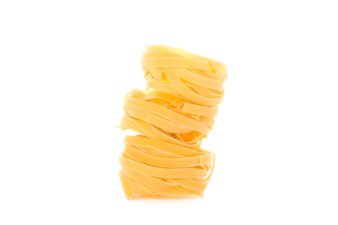 Pasta isolated on light background. Uncooked whole wheat pasta