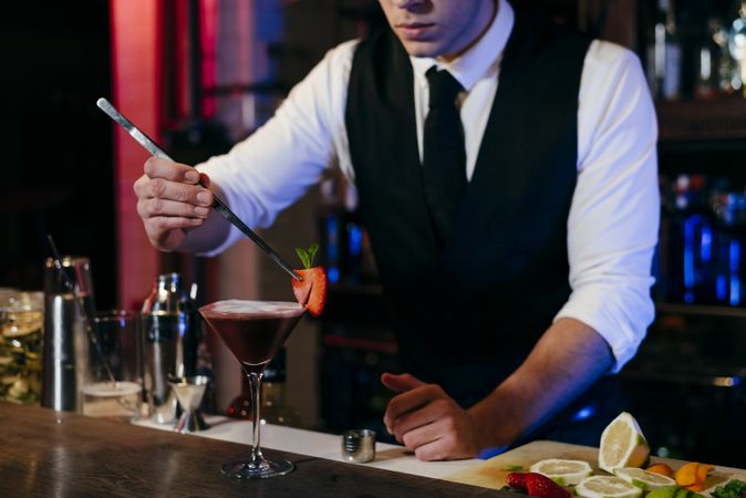 Barman working preparing drink in a glass