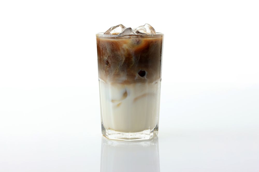 Homemade Ice Coffee Milk in a Tall Glass with Milk Cream