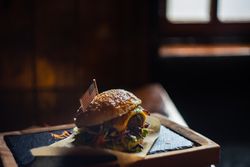 Cheeseburger with melted cheese and vegetables on brown paper