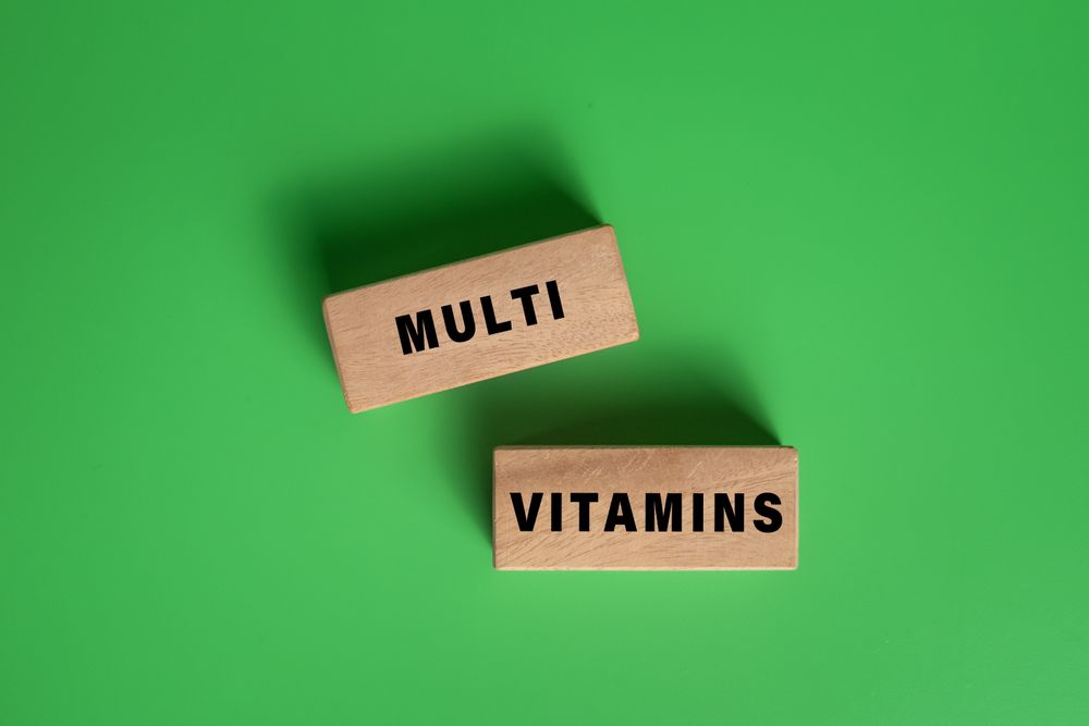 multi vitamins words on wooden blocks isolated on green background