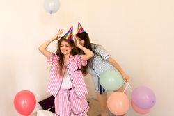 Family fun with balloons and party hats in living room.
