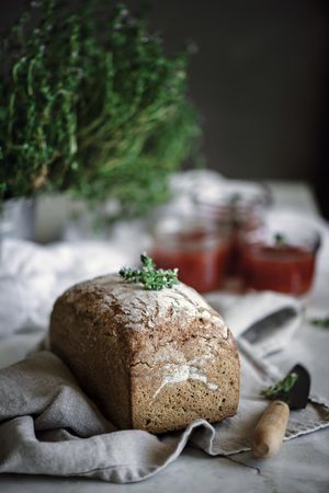 Fresh bread on napkin near tomatoes jam