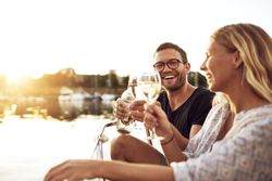 Couple toasting with wine glasses a boat