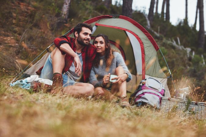 Couple sitting together in front of their tent
