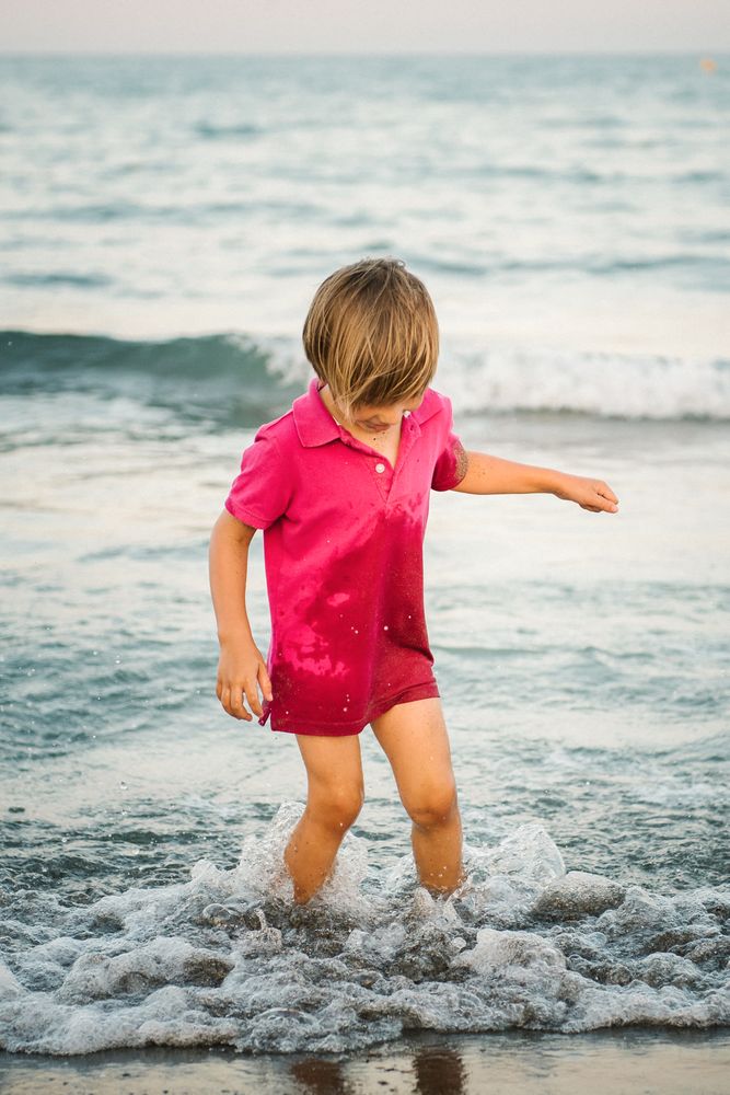 Playful boy splashing water on coast