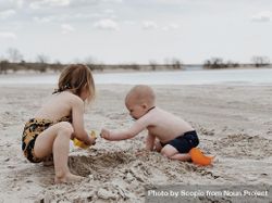 Two kids playing in the sand 5RB9W5