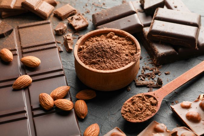 Chocolate, melted chocolate and almond on dark background