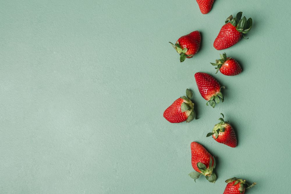 Ripe strawberries pile on a green table