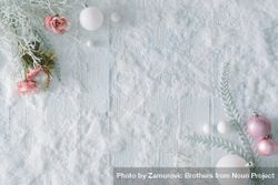 Wooden table background with snow and flowers and festive pink decorations 0KgKV0
