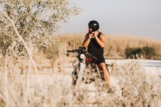 Serious male driving motorcycle in forest