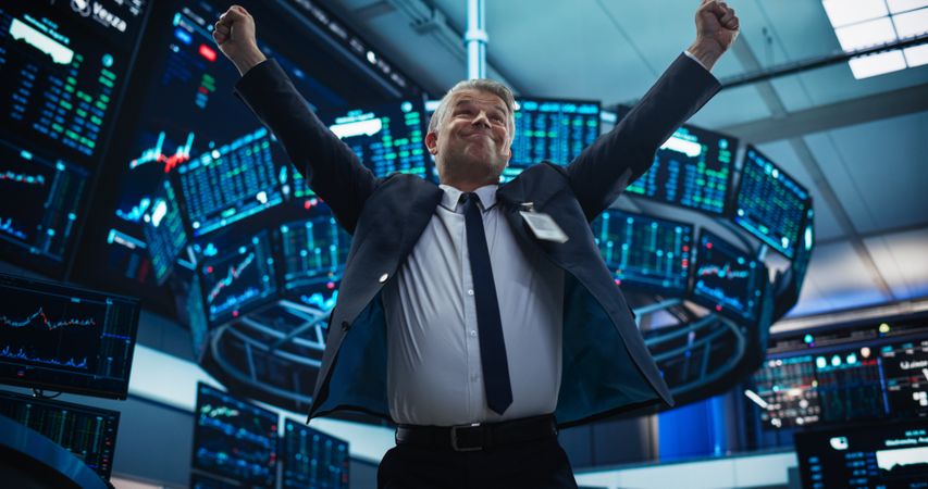Stock Market Day Trader Working at an Exchange Office with Multi-Monitor Setup with Real-Time Investment, Commodities and Foreign Funds Charts.