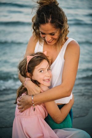 Beautiful mother and daughter embracing on beach