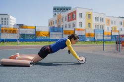 A young woman does an exercise at the stadium