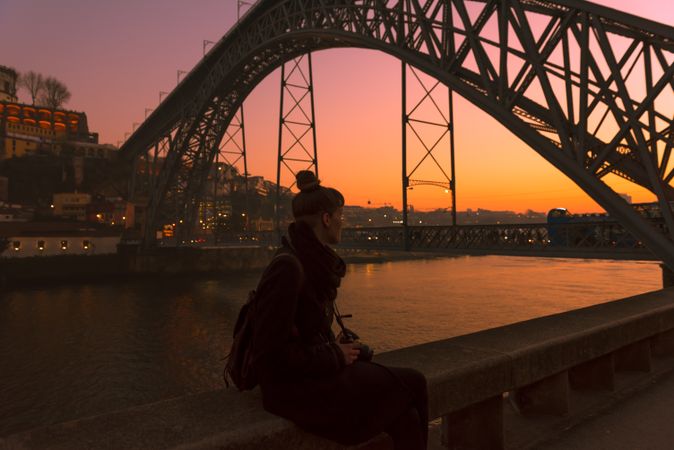 Woman looking at river and city in evening