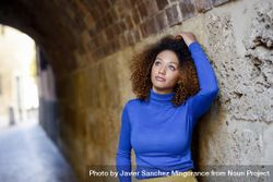 Nonchalant Woman With Curly Hair Looking Up And Touching Her Hair ...