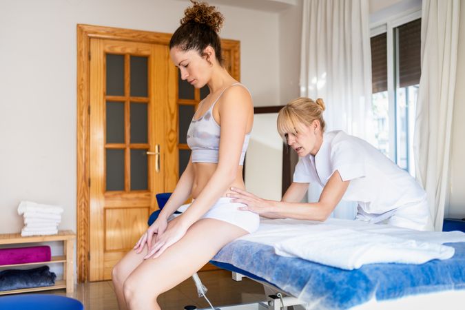 Female client receiving treatment in physiotherapy clinic from osteopath