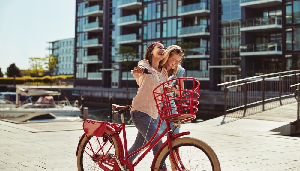 Two close female friends happily walking along the waterfront