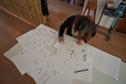 Female designer painting sketches on paper